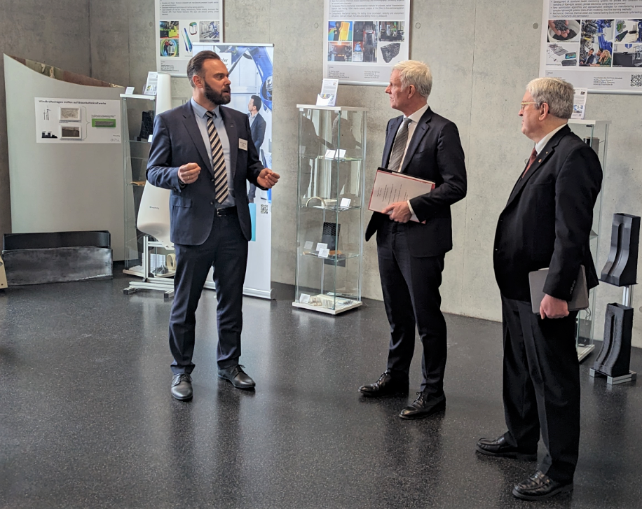 Prof. Holger Seidlitz (left) presents Stephan Schwarz (center) and Prof. Dr.-Ing. Jörg Steinbach (right) with current developments from the PYCO research area of Fraunhofer IAP.